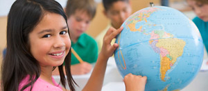 A smiling student studies geography at her local public school.